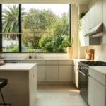 Modern handleless kitchen with white cabinets and marble worktop