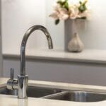 Kitchen sink area with water supply and modern cabinets